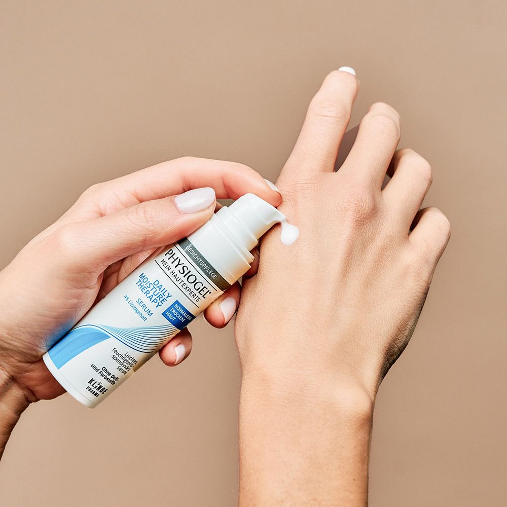 Mains avec sérum. Texte : PHYSIOGEL, Daily Moisture Therapy, Sérum. Pour peaux normales à sèches.