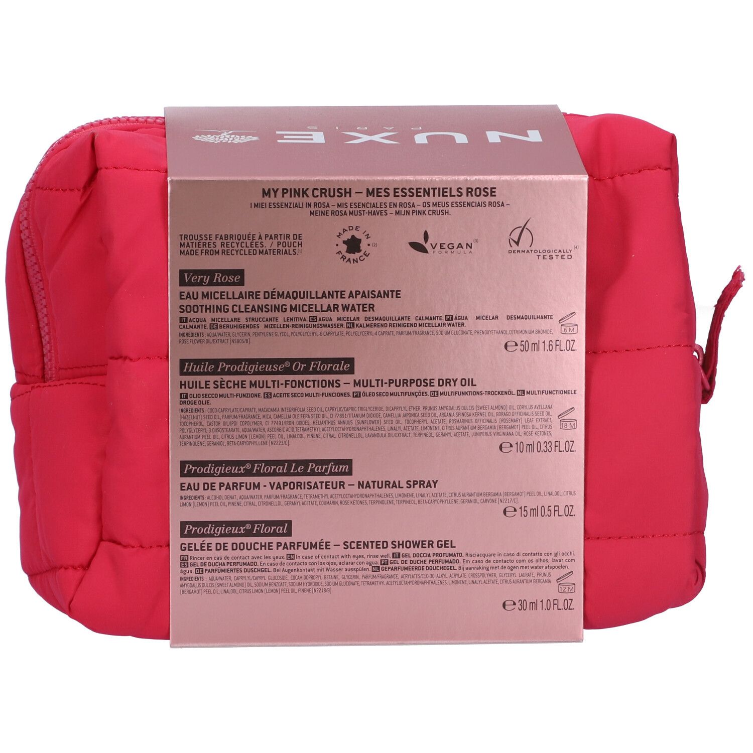 Dos de l'emballage du produit avec texte. Contient les noms des produits et les ingrédients. Trousse de toilette rose en arrière-plan.