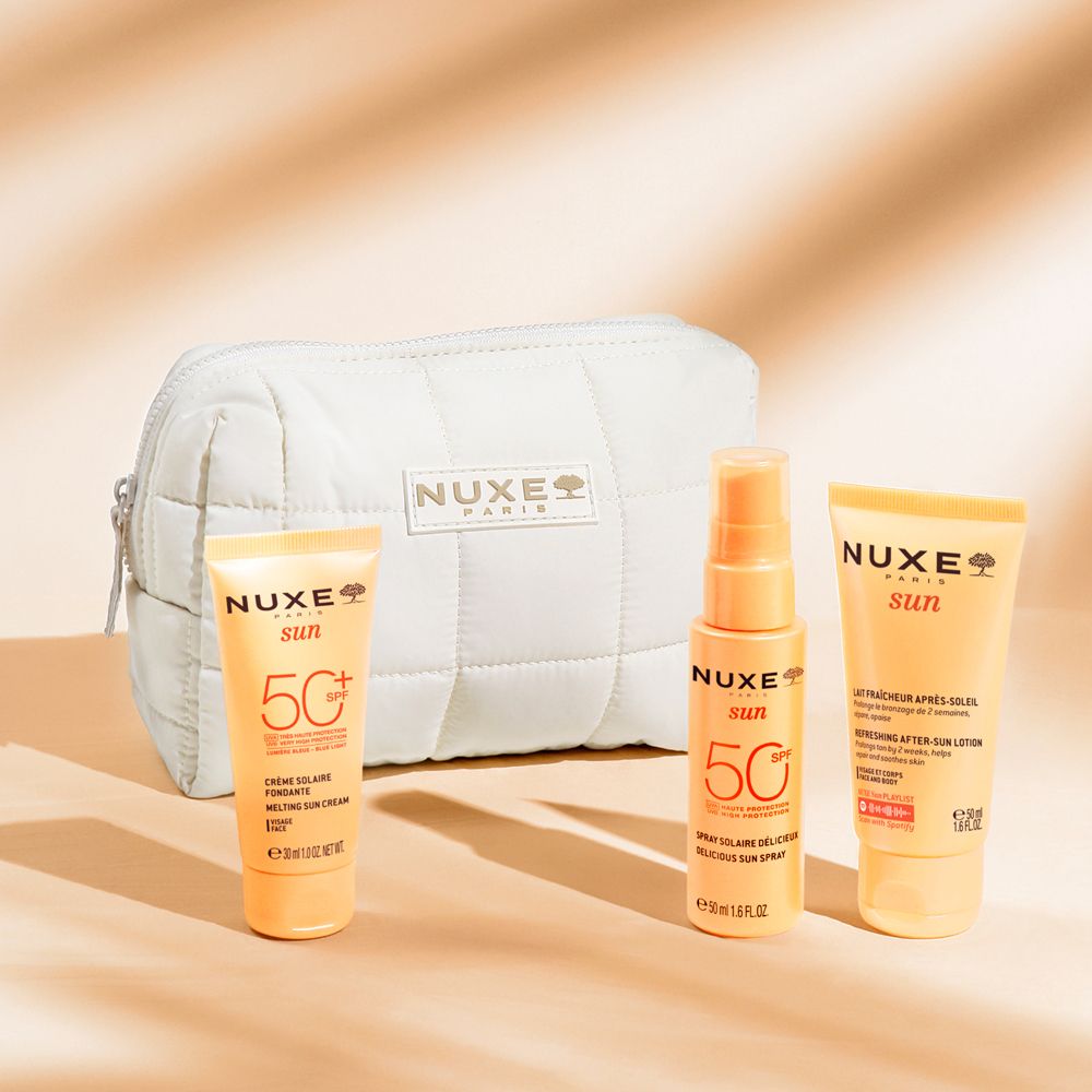 Beige Kosmetiktasche und drei Sonnenpflegeprodukte. Aufdruck: Nuxe Sun, 50+.