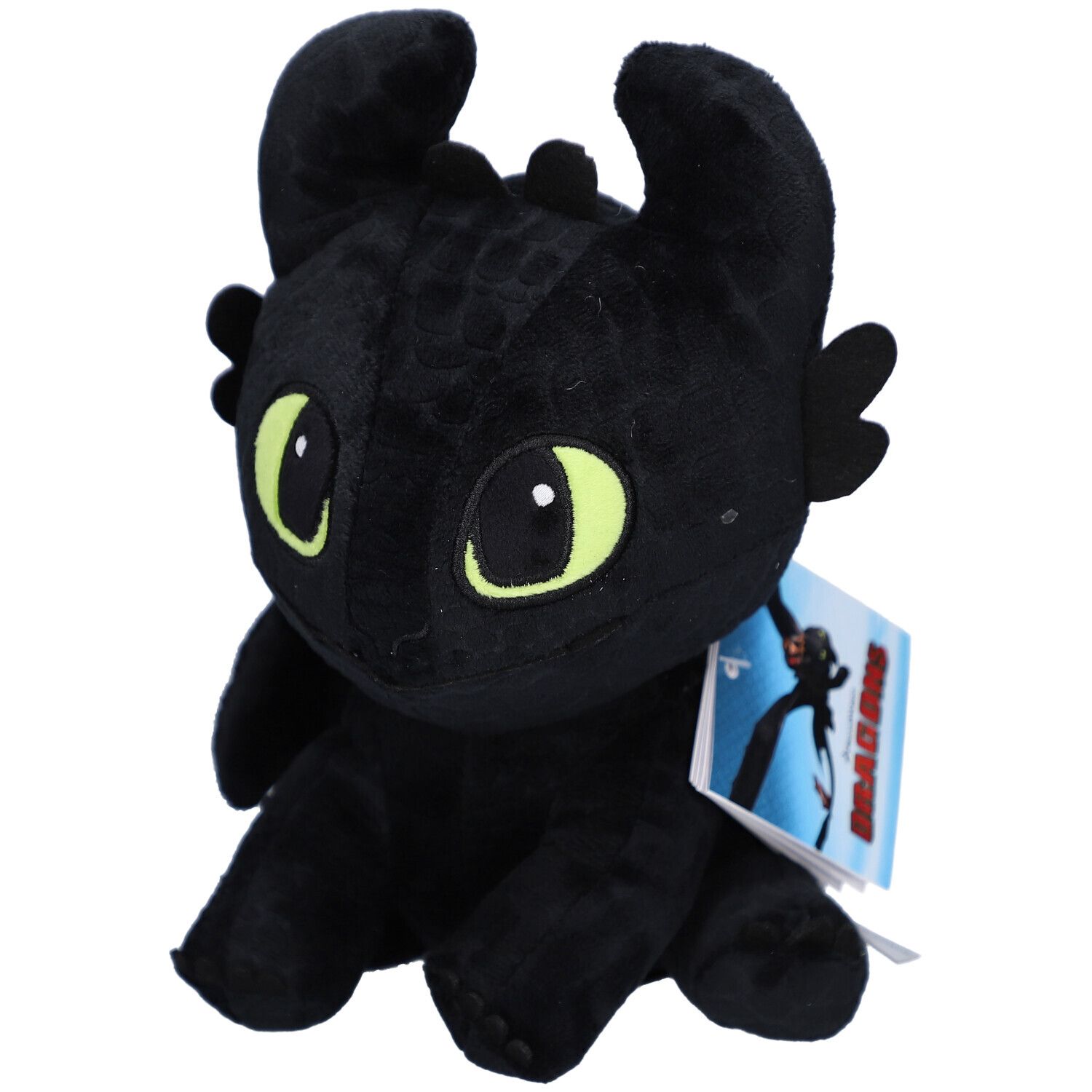 Peluche noire en forme de dragon, yeux verts, oreilles, ailes. Étiquette avec image. Fond clair.