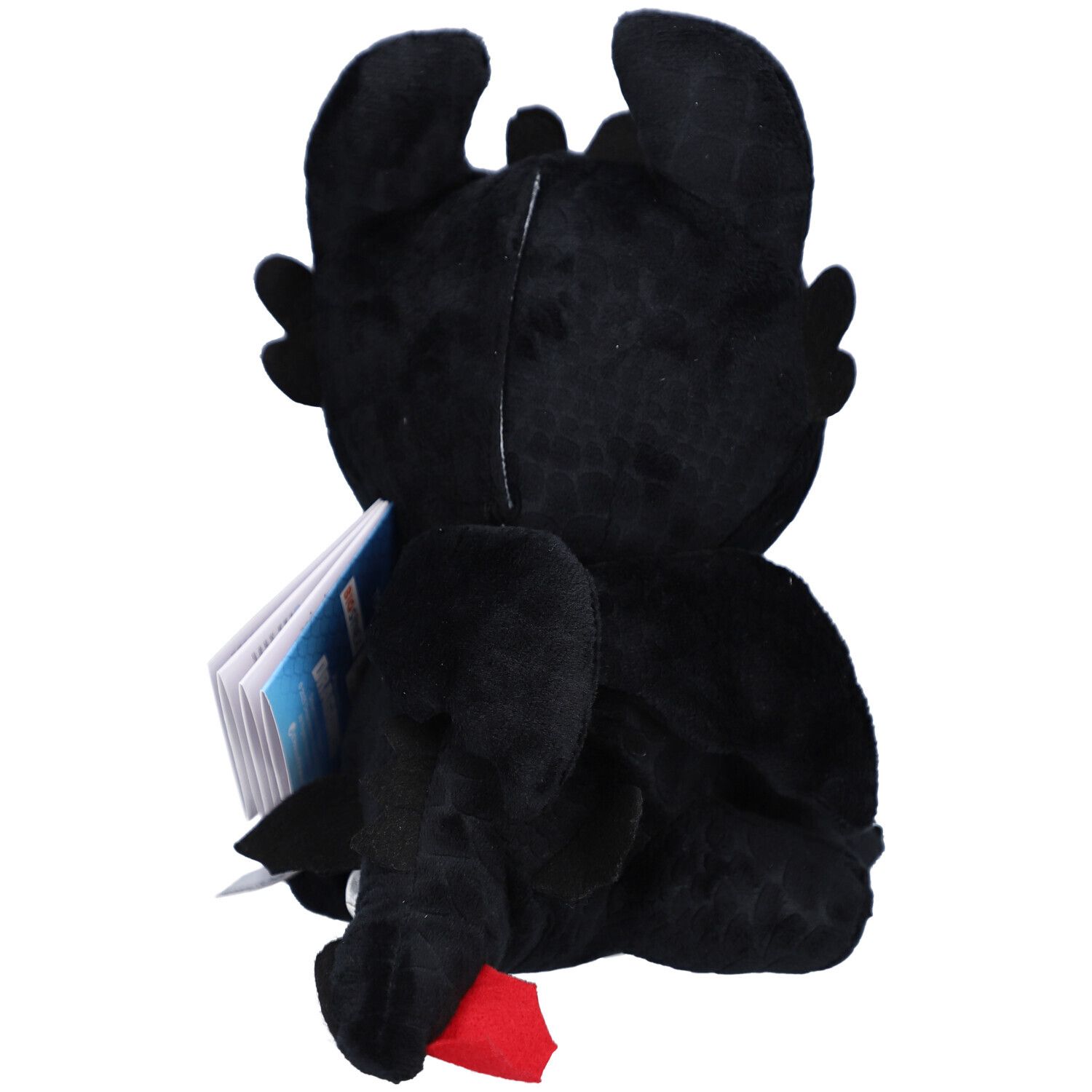 Peluche noire en forme de dragon, yeux verts, oreilles, ailes. Étiquette. Vue arrière.