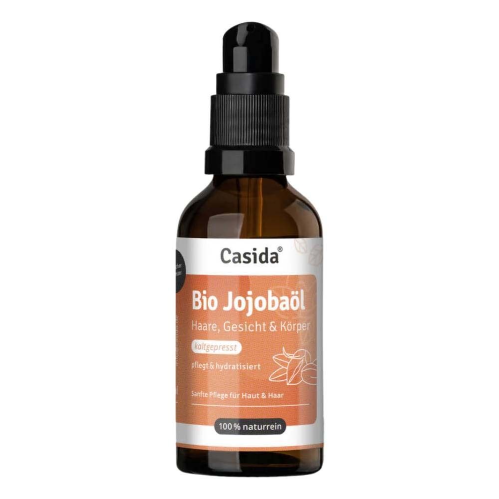 Braune Glasflasche mit Pumpspender, Etikett mit "Casida Bio Jojobaöl" und Pflanzenabbildung.