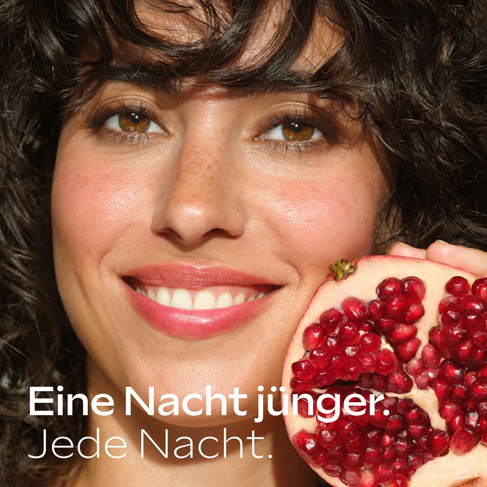 Lächelnde Frau mit dunklen Haaren hält Granatapfelhälfte. Text: Eine Nacht jünger. Jede Nacht.