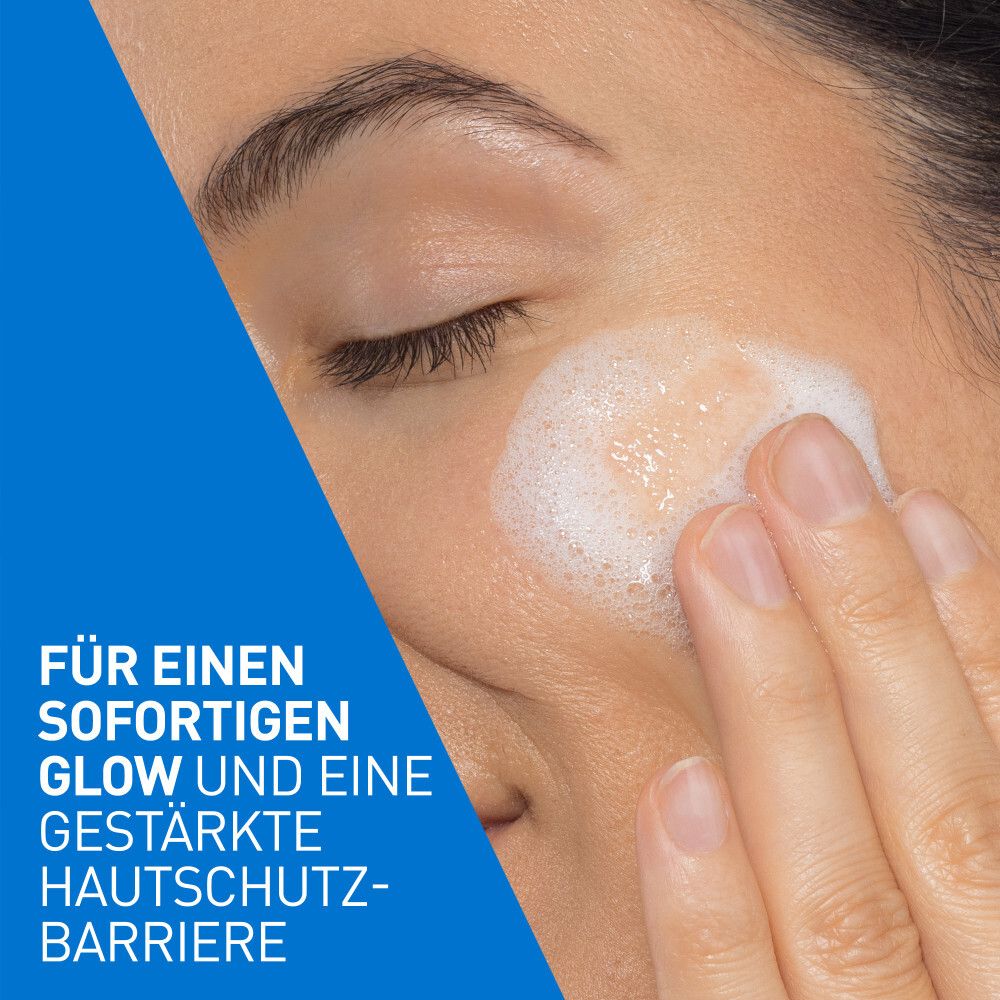 Gesicht einer Frau mit schäumendem Reinigungsprodukt auf der Haut.