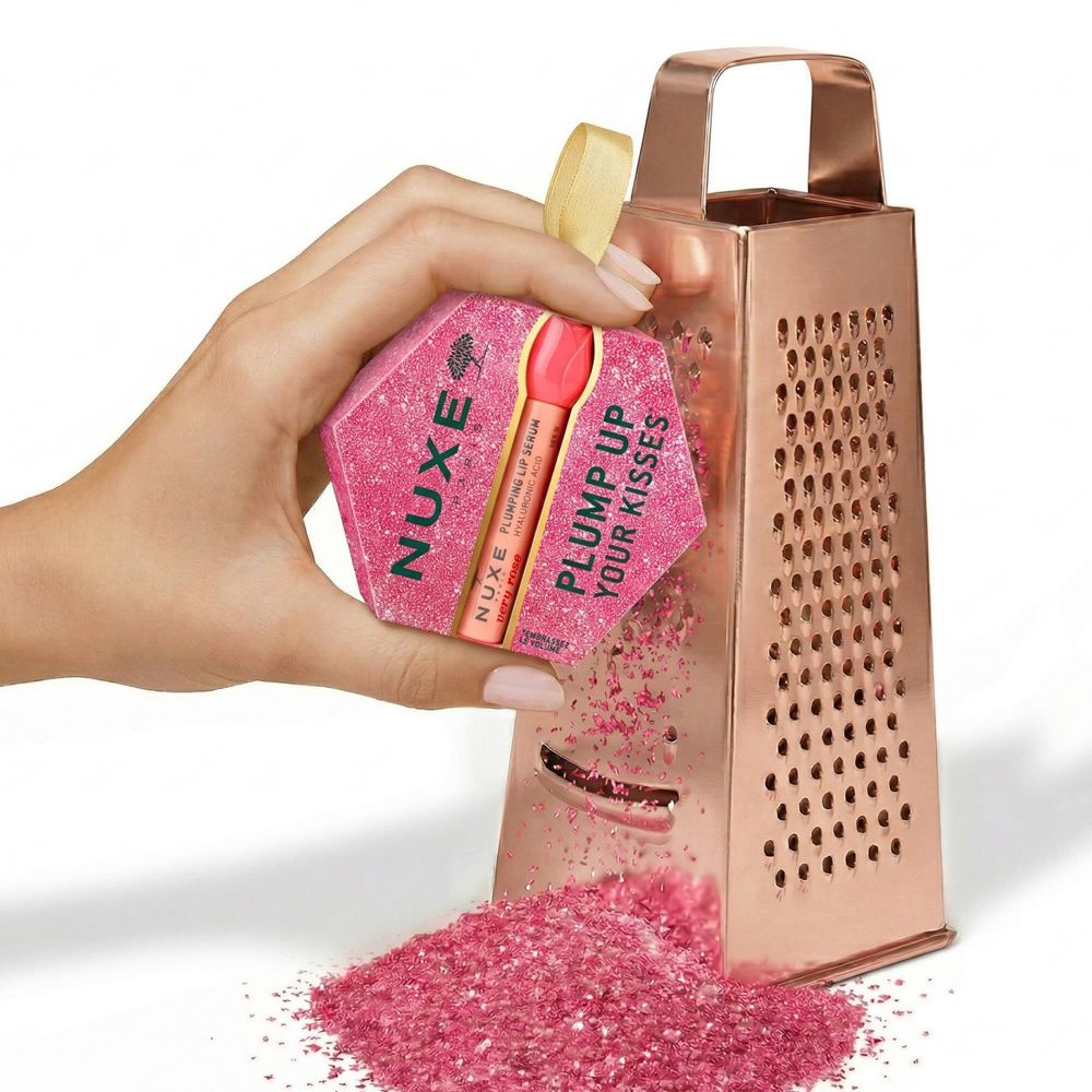 Nuxe Lippenpflege-Set in sechseckiger Verpackung, wird durch eine Reibe gerieben.
