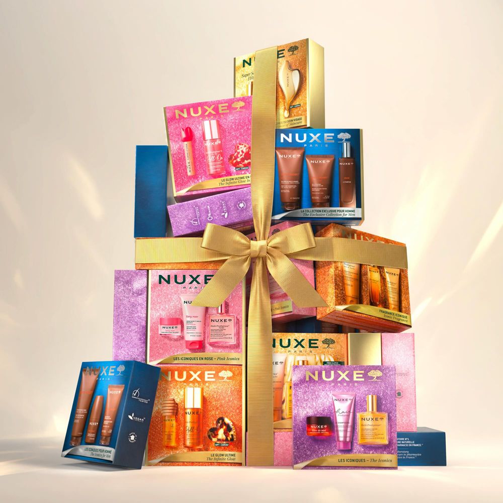 Ein gestapeltes Geschenkset von Nuxe mit Kosmetikprodukten, gebunden mit einer goldenen Schleife.