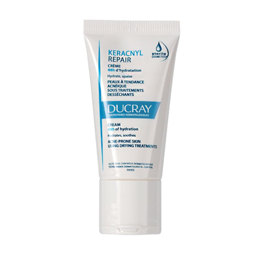 Weiße Tube mit blauer Schrift. Aufschrift: KERACNYL REPAIR CREME, DUCRAY. Für zu Akne neigende Haut unter Austrocknungsbehandlungen.
