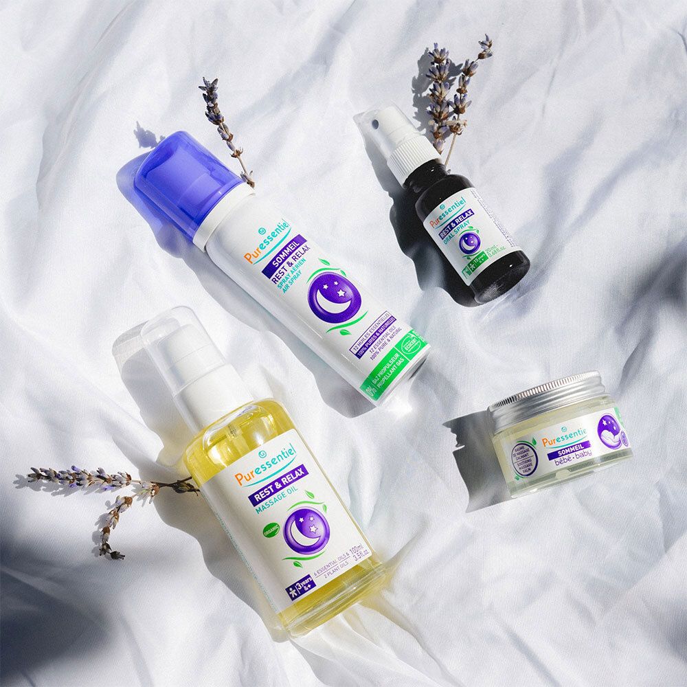 Verschiedene Puressentiel Produkte: Massageöl, Spray, Creme. Lavendelzweige. Mond- und Stern-Symbol.