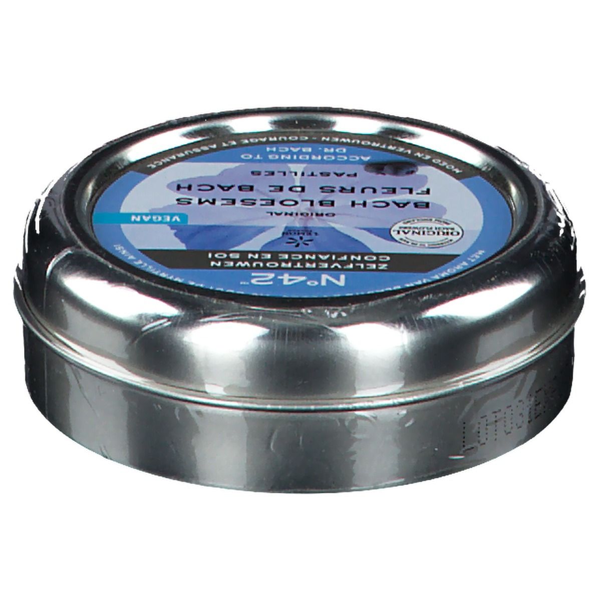 Boîte métallique ronde, légèrement inclinée. Étiquette bleue avec inscription: Fleurs du Dr. Bach Pastilles, Confiance en soi. Vegan.