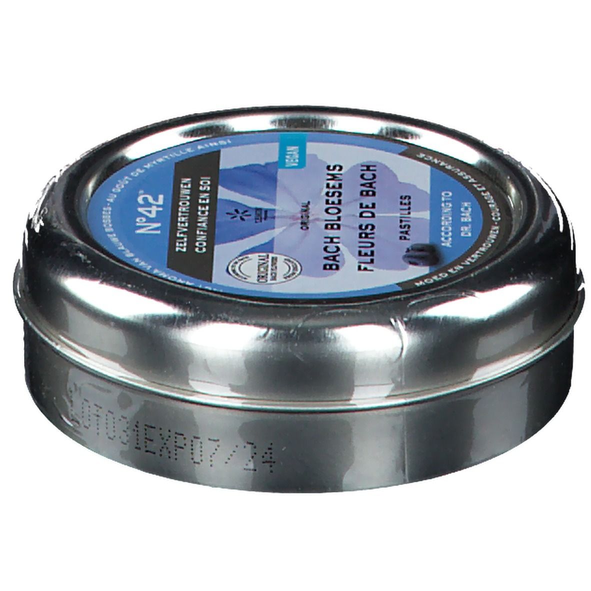 Boîte métallique ronde, légèrement inclinée. Étiquette bleue avec inscription: Fleurs du Dr. Bach Pastilles, Confiance en soi. Vegan.