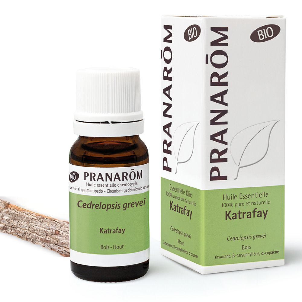 Braune Glasflasche mit weißem Verschluss und Karton. Aufschrift: Pranarôm, Katrafay, Bio. Holzstück daneben.