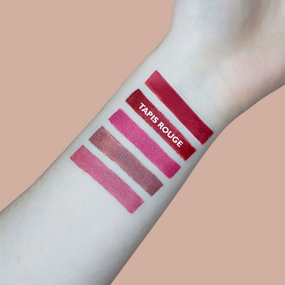 Arm mit fünf Lippenstiftfarben. Aufschrift: Tapis Rouge.