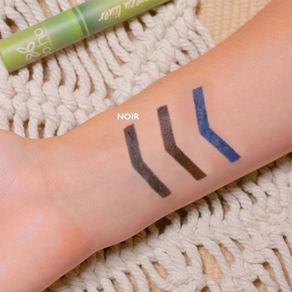 Arm mit drei Eyeliner-Strichen: Schwarz, Braun, Blau. Produktname: BOHO Green Liner. Aufschrift: NOIR.