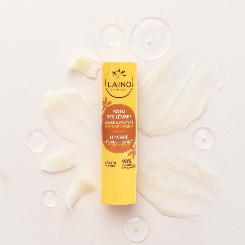 Gelber Lippenpflegestift mit LAINO, Soin des Lèvres, Vanille. Umgeben von Creme- und Öl-Klecksen. 98% natürliche Inhaltsstoffe.