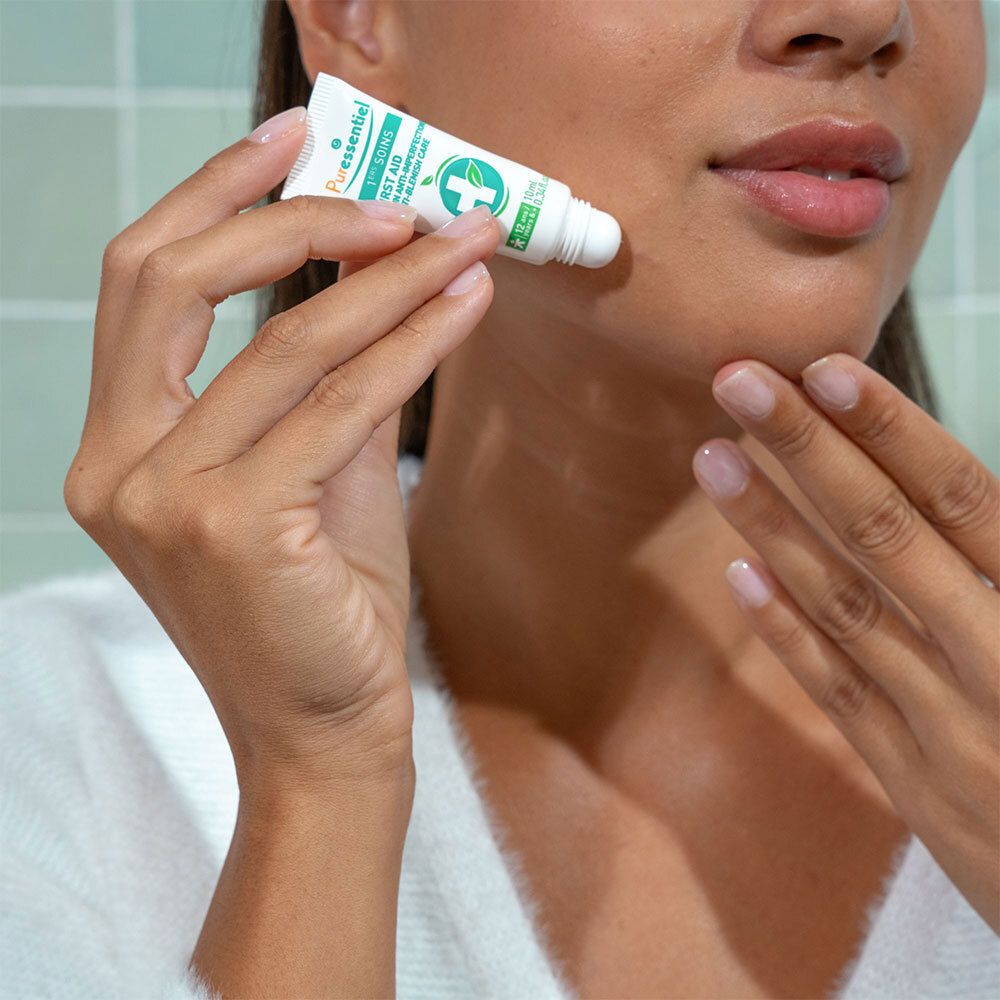 Frau hält Tube. Aufschrift: Puressentiel 1. SOINS Anti-Imperfektionen. 10 ml.