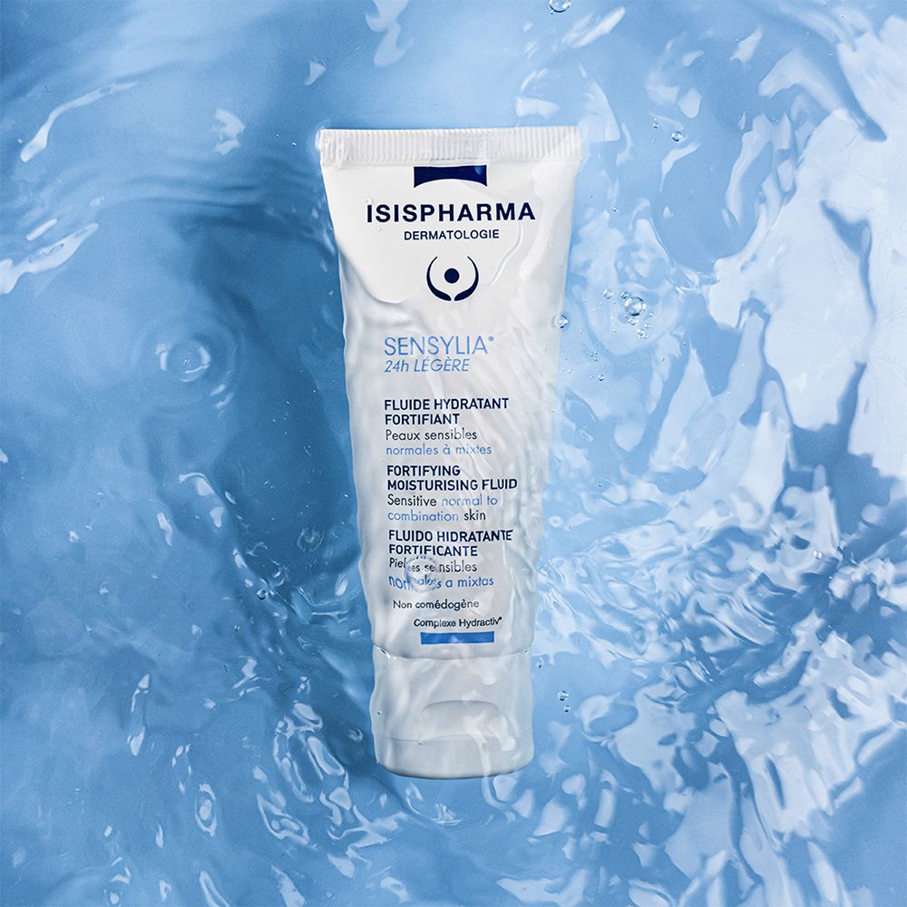 Weiße Tube Sensylia 24h Légère im Wasser. Marke ISISPHARMA. Für empfindliche Haut. Blaue Wellen im Hintergrund.