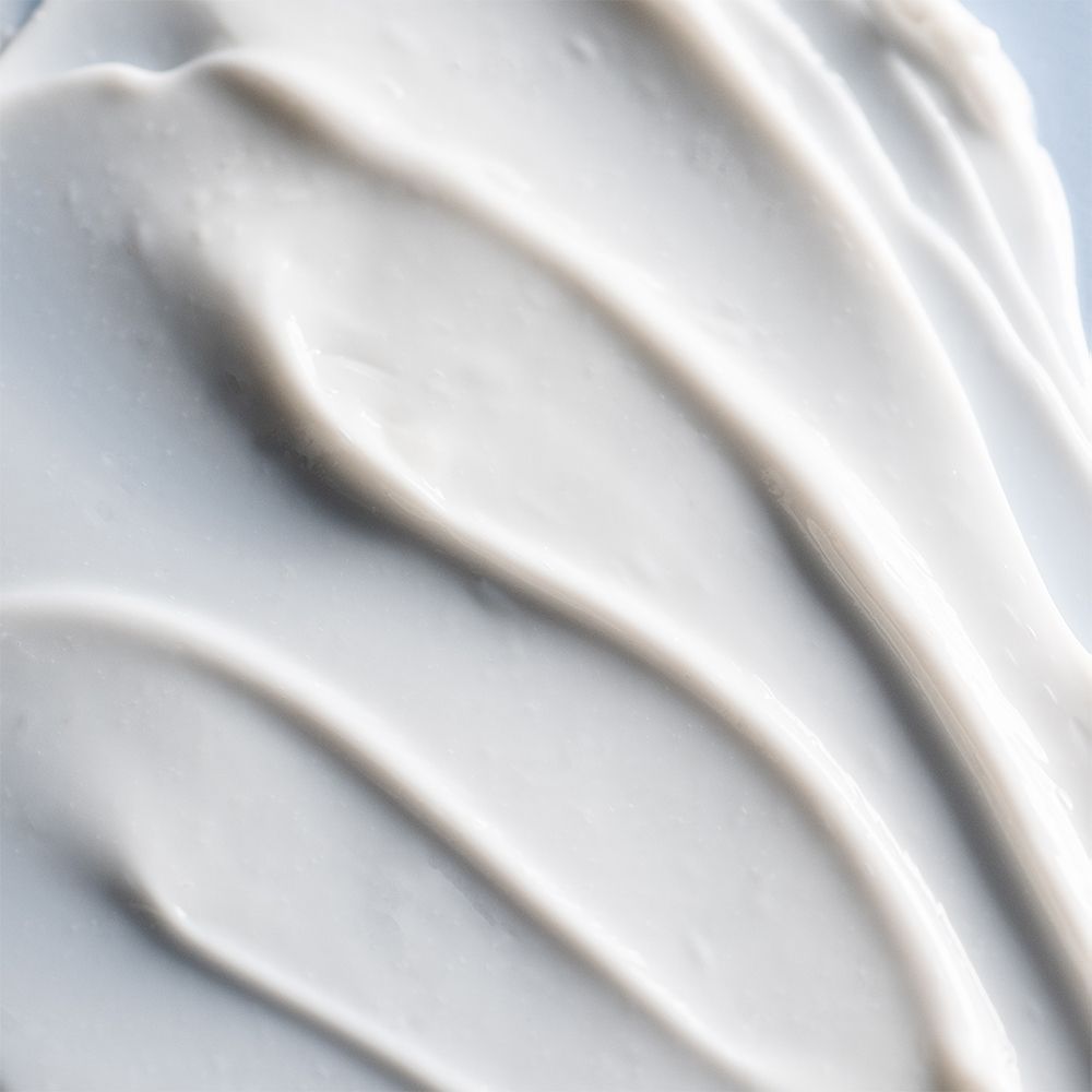 Nahaufnahme von weißer Creme. Wellenförmige Textur. Keine Verpackung oder Produktnamen.