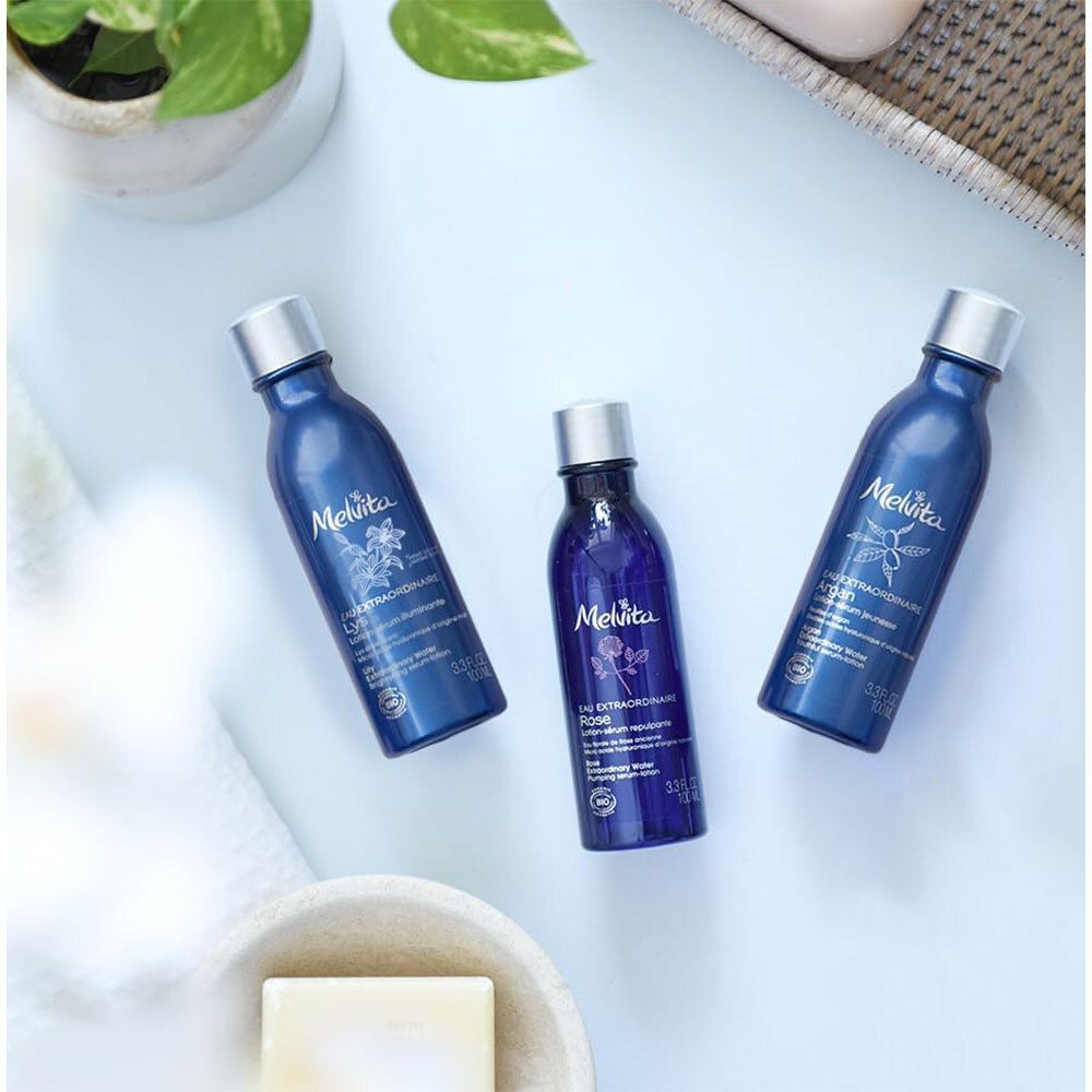 Drei blaue Flaschen mit silbernen Deckeln. Aufschrift Melvita und Produktnamen. Auf hellem Untergrund.