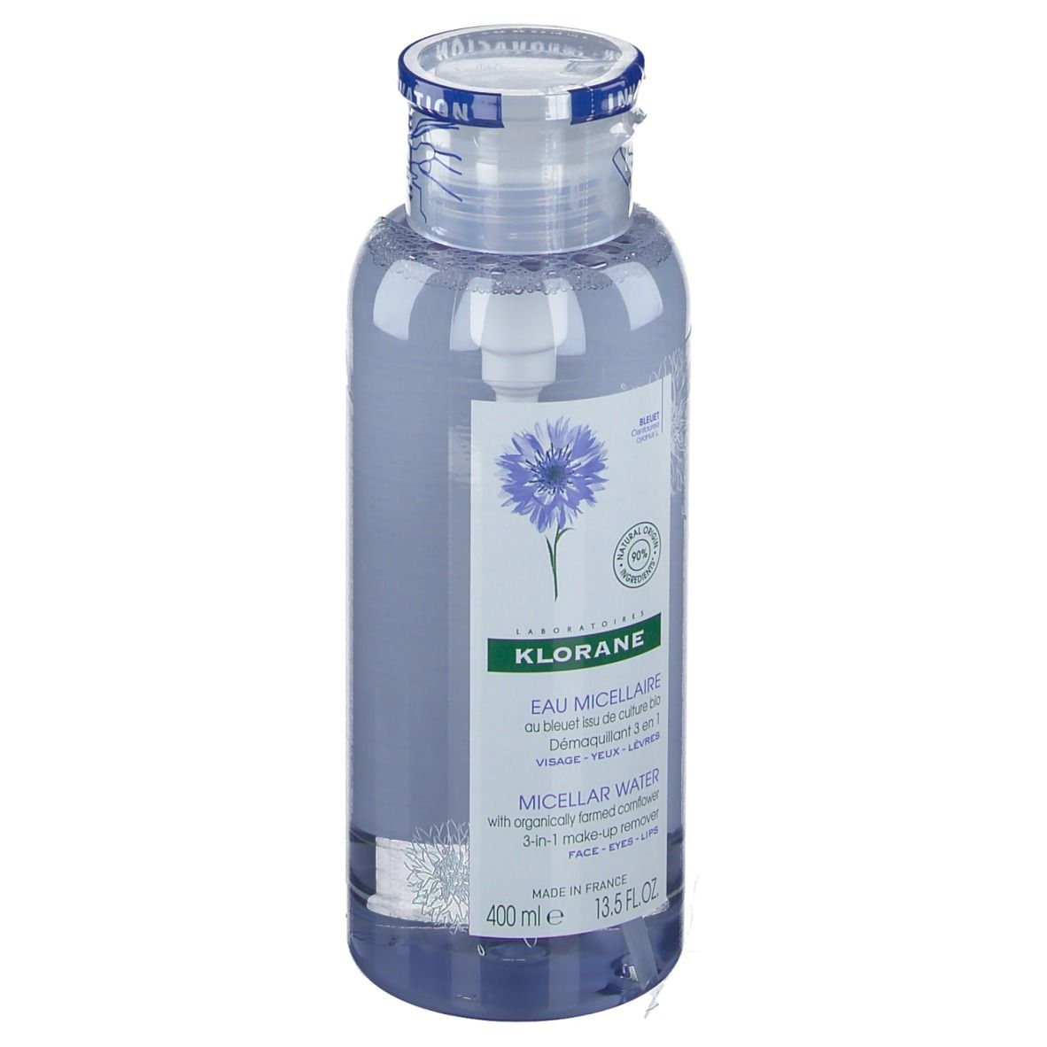 Flacon transparent avec liquide bleu. Étiquette avec nom du produit et illustration de bleuet. Bouchon avec bande bleue.