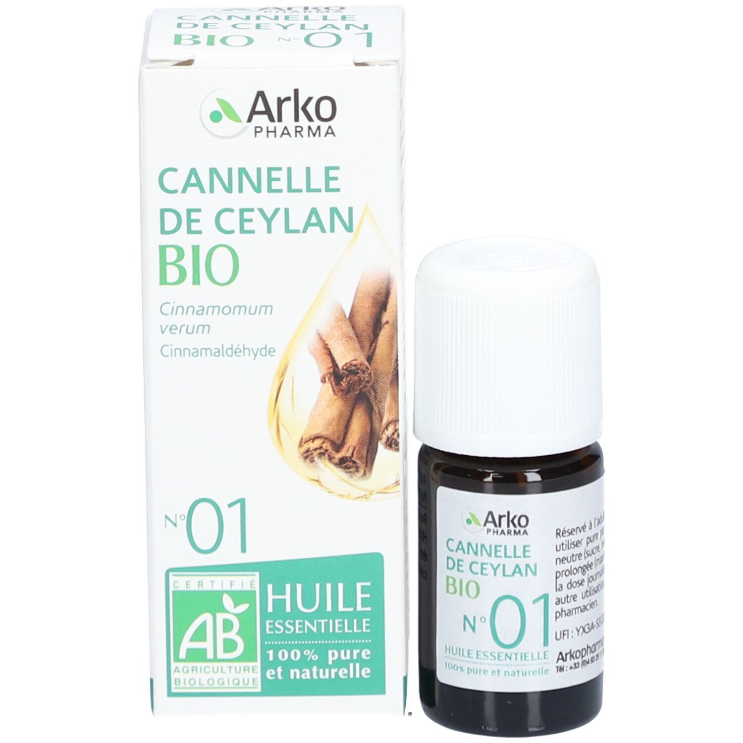 Produktflasche und Verpackung. Flasche: braunes Glas, weißer Deckel. Verpackung: weiß, grün, Zimtstangen-Illustration.