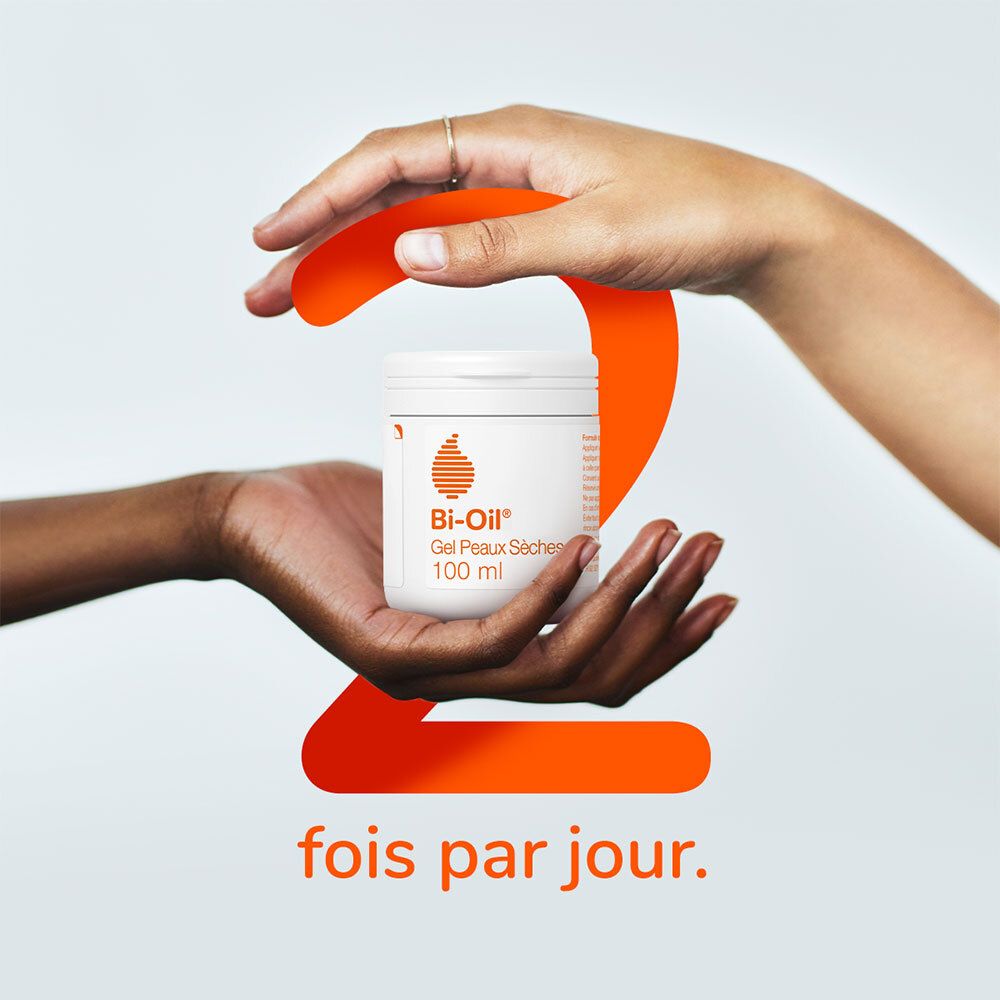 Hände halten einen weißen Tiegel mit Bi-Oil® Gel Peaux Sèches. Große orangefarbene 2.