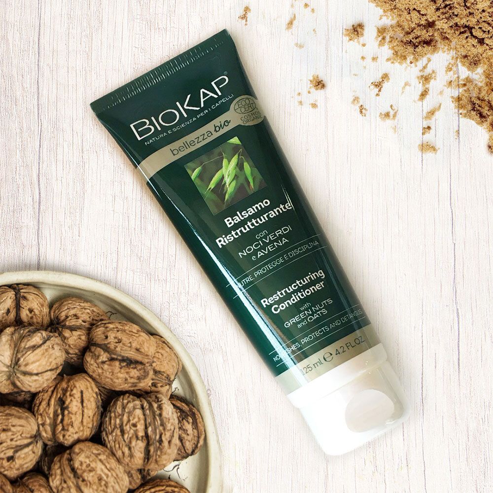 BIOKAP Balsamo Ristrutturante. Tube, vert, blanc. Texte: Balsamo Ristrutturante, Restructuring Conditioner. Noix et avoine.