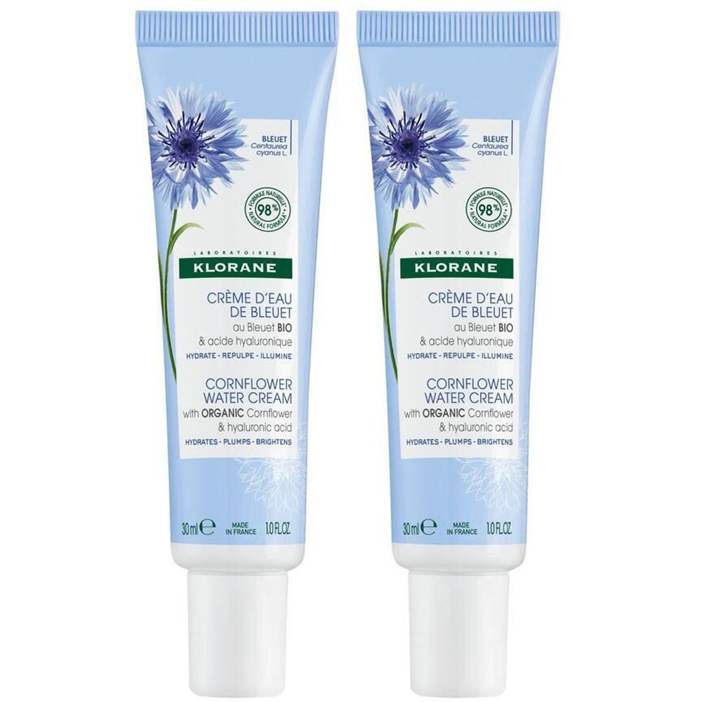 Deux tubes bleu clair avec fleur bleue et texte. Contient Crème d'Eau de Bleuet. 30ml. 98% d'ingrédients naturels.