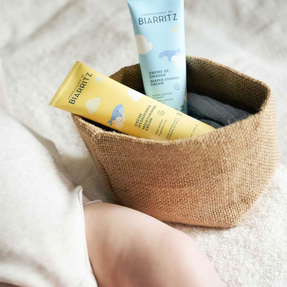 Deux tubes dans un panier. Inscription: Laboratoires de Biarritz, Crème Hydratante, Crème de Change, Diaper Change Cream.
