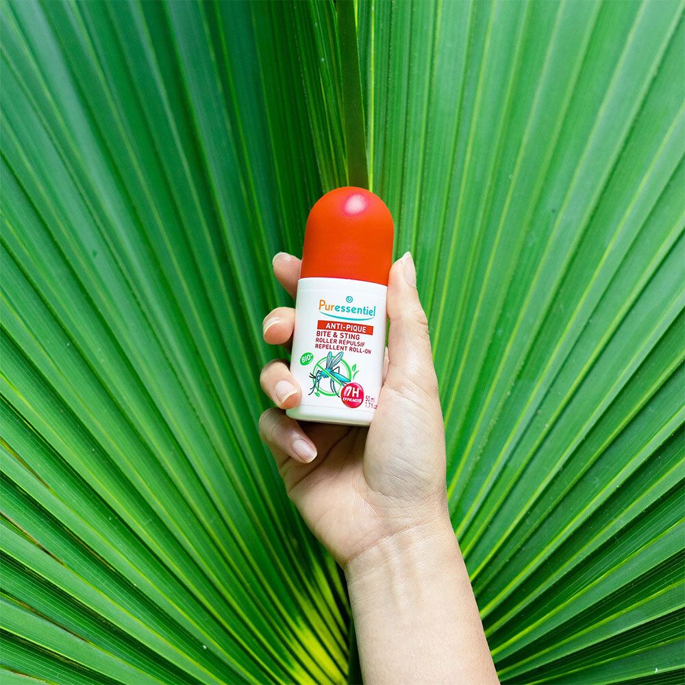 Roll-on Anti-Pique Puressentiel. Flacon blanc, bouchon rouge. Sur feuilles vertes.