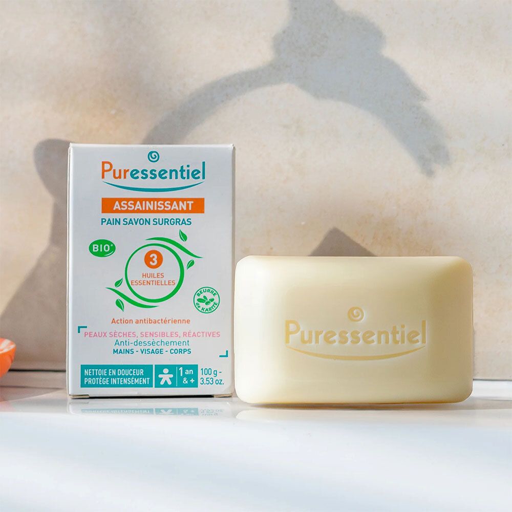 Verpackung und Seifenstück. Aufschrift: Puressentiel, Assainissant, Pain Savon Surgras.