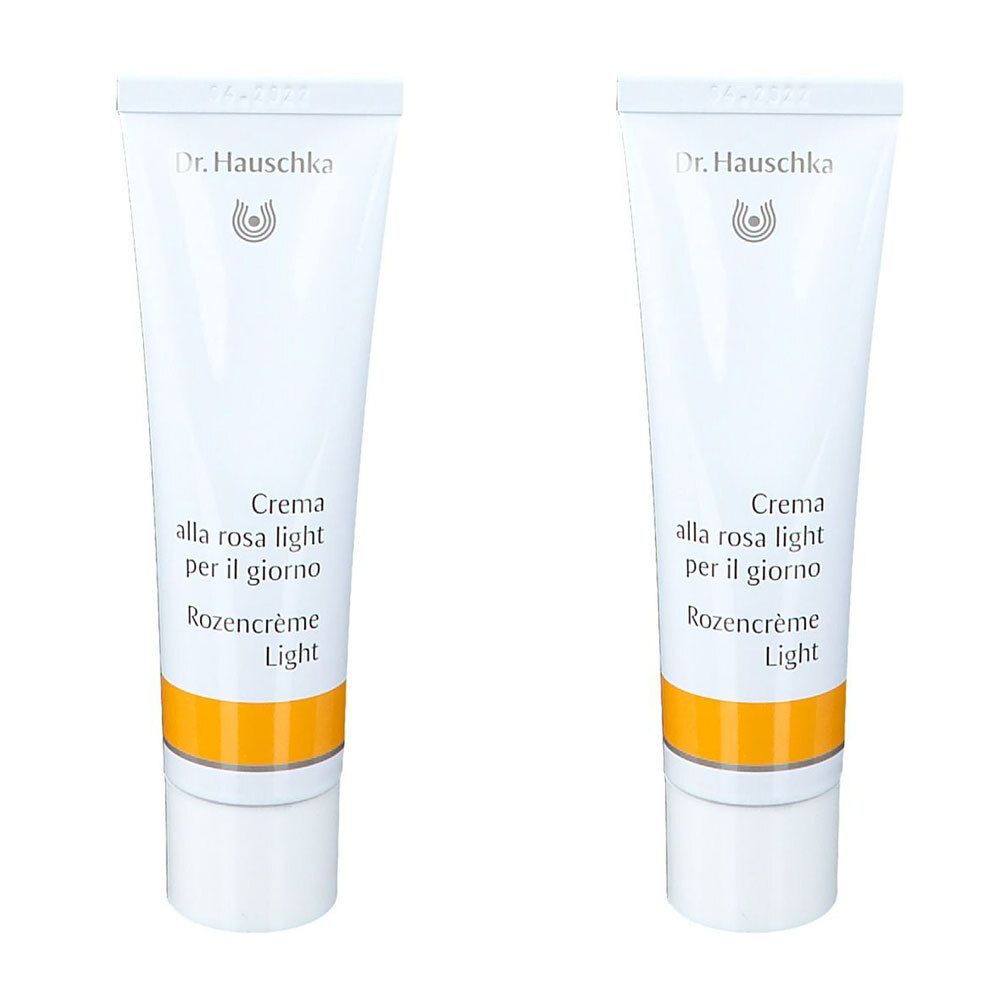 Deux tubes de crème. Tubes blancs avec bande jaune. Inscription: Dr. Hauschka, Crema alla rosa light, Rozencrème Light.