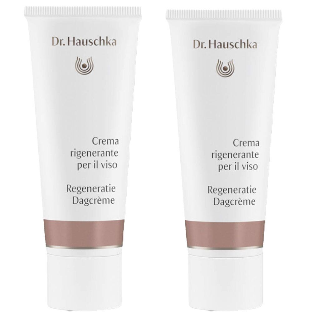 Zwei Tuben Creme. Weiß, mit braunem Streifen. Schriftzug: Dr. Hauschka, Creme rigenerante per il viso, Regeneratie Dagcrème.