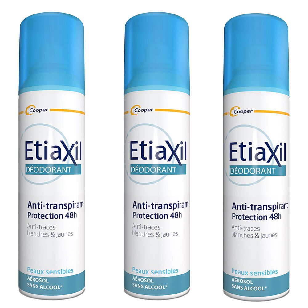 Trois aérosols Etiaxil. Bouchon bleu, étiquette blanche avec texte: Anti-transpirant 48h, peaux sensibles, sans alcool. Marque Cooper en haut.