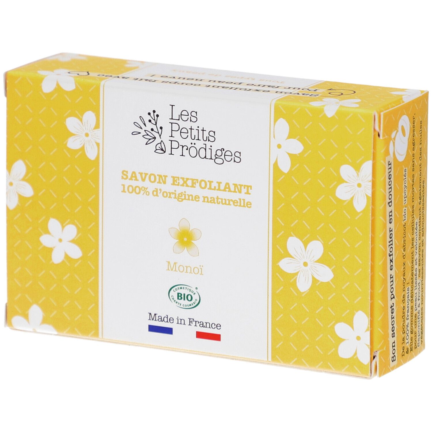 Boîte jaune à motifs floraux blancs. Inscription: SAVON EXFOLIANT, 100% d'origine naturelle, Monoi, BIO. Drapeau français.