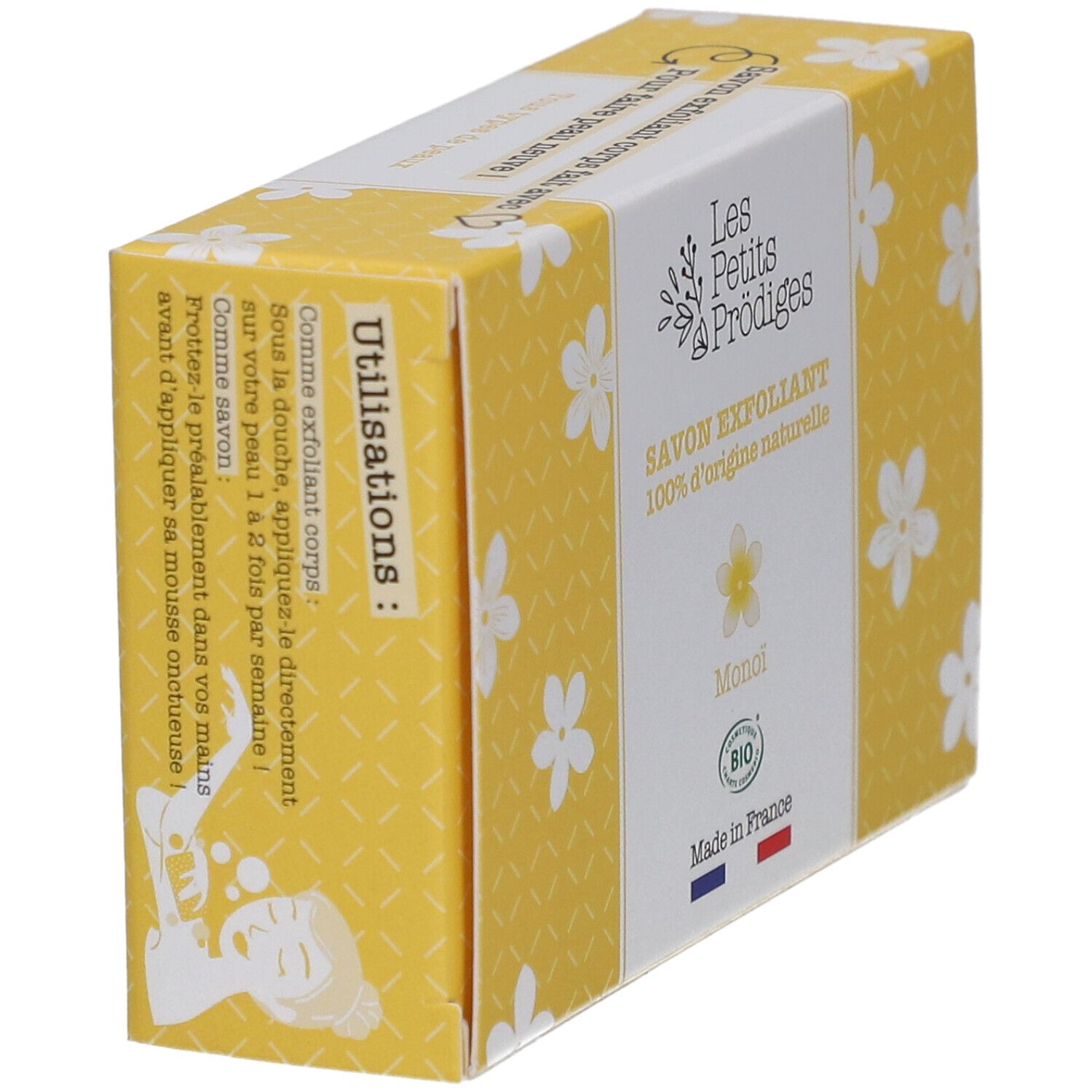 Boîte jaune à motifs floraux blancs. Inscription: SAVON EXFOLIANT, 100% d'origine naturelle, Monoi, BIO. Drapeau français. Instructions d'utilisation.