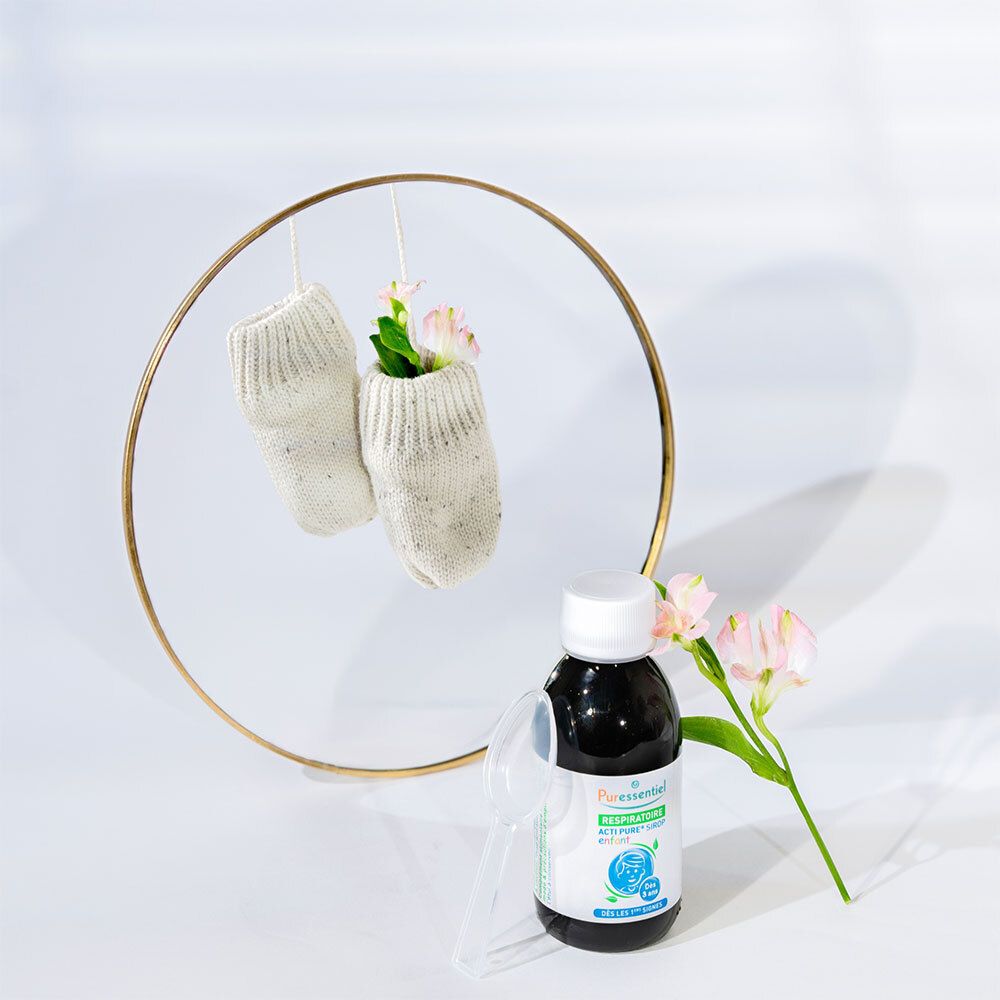 Flasche mit brauner Flüssigkeit, Löffel und Socken in einem goldenen Ring. Aufschrift: Puresentiel Acti Pure.