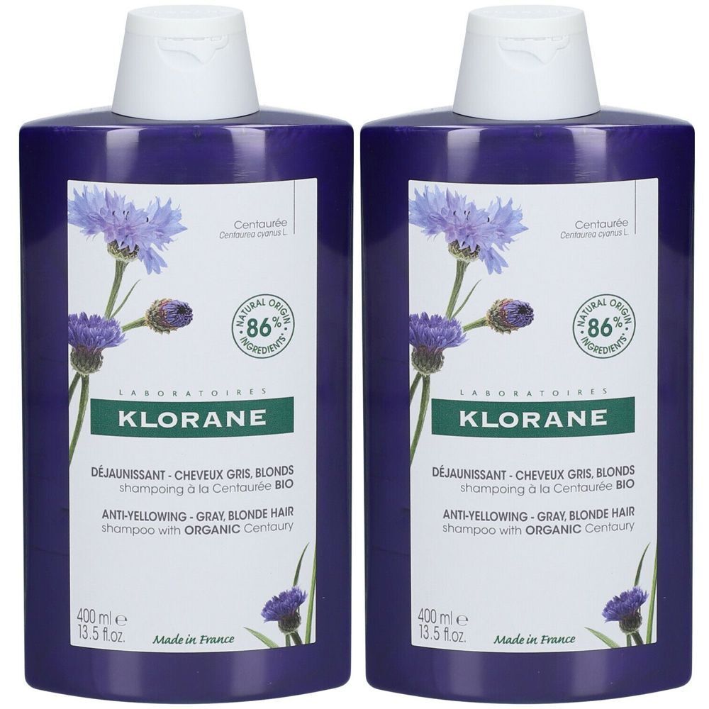 Deux flacons violets de shampooing KLORANE. Étiquettes avec illustration de bleuets et texte. 86% ingrédients naturels. 400 ml.