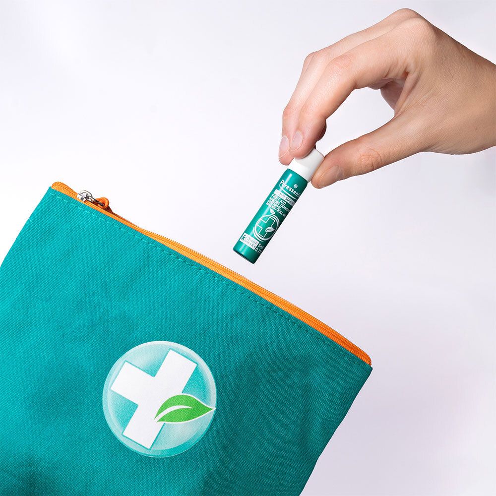 Hand benutzt Puressentiel Roller Mal des Transports, 5ml, aus einer Kosmetiktasche.