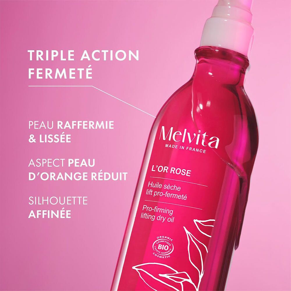 Melvita L'Or Rose Ölflasche. Rosa Flüssigkeit, weißer Sprühkopf. Text: Triple Action Fermeté, Peau Raffermie & Lisse, Aspect Peau d'Orange Réduit, Silhouette Affinée.