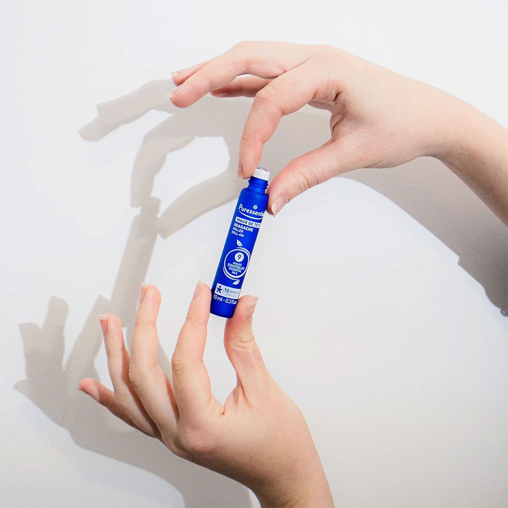 Person hält blaues Roll-on. Marke: Puressentiel. Text: Maux de tête. Kleines Produkt.