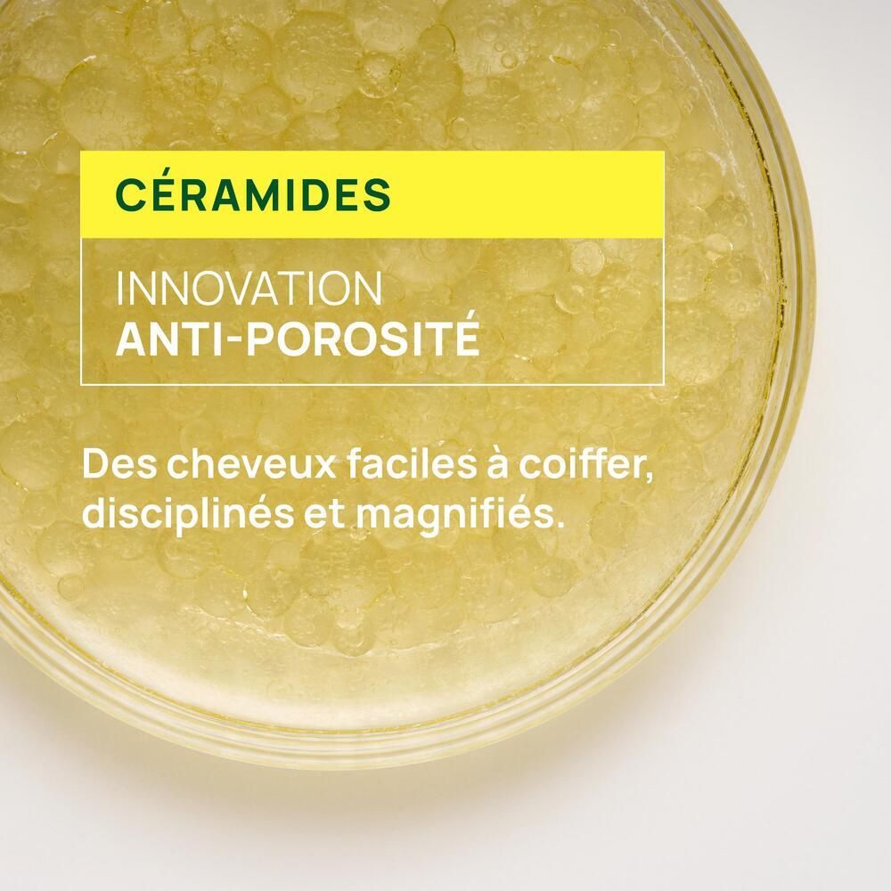 Nahaufnahme von gelben Kügelchen. Text: CÉRAMIDES, INNOVATION ANTI-POROSITÉ. Für leicht kämmbares, diszipliniertes Haar.