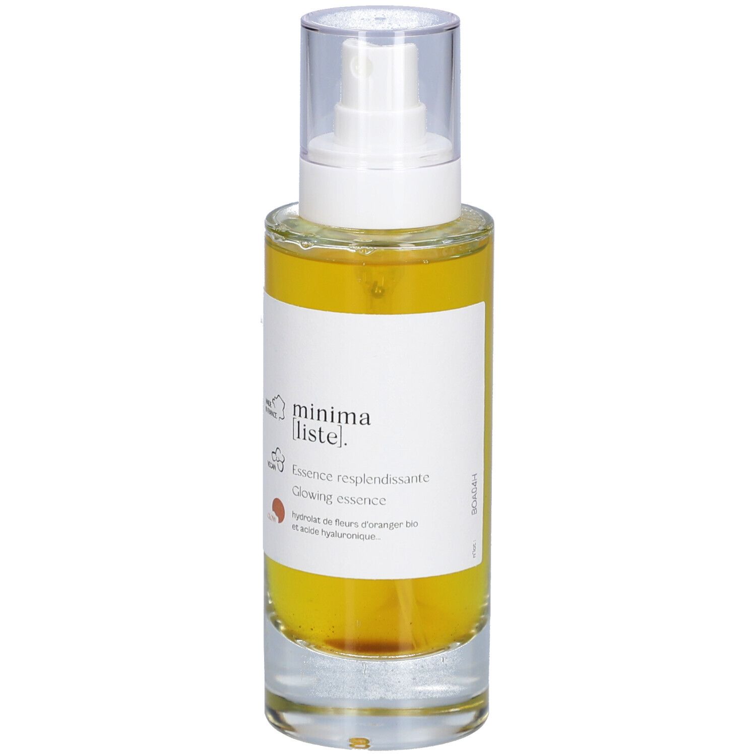 Flacon en verre avec liquide jaune et vaporisateur. Inscription : minima liste. Essence resplendissante, Glowing essence.