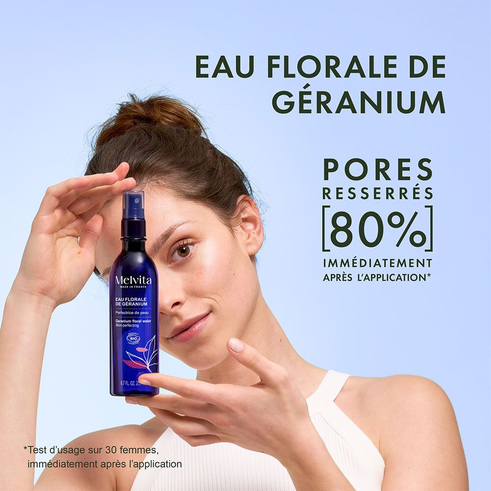 Femme tenant un flacon pulvérisateur bleu. Texte: Eau Florale de Géranium, Pores resserrés 80% immédiatement après l'application. Melvita.