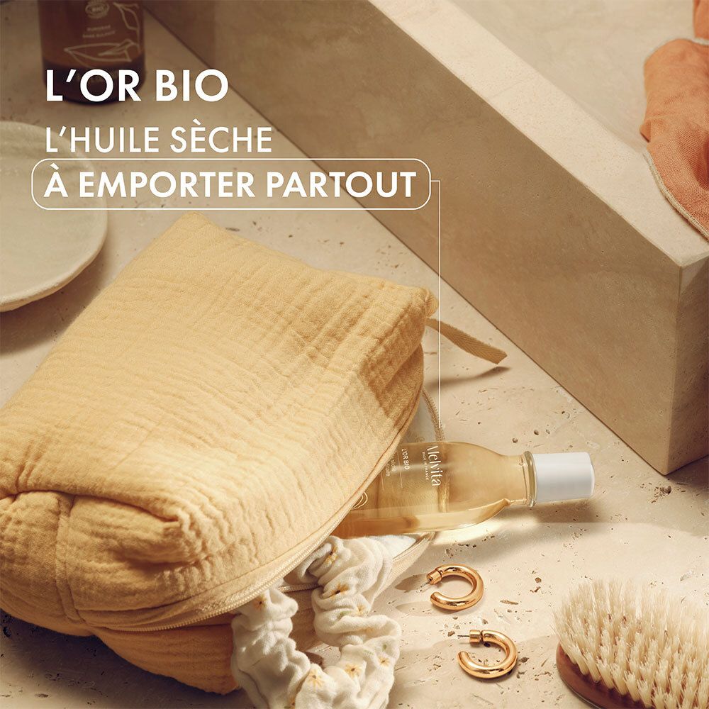 Gelbe Kosmetiktasche mit Melvita L'Or Bio Ölflasche, Ohrringen und Haarbürste. Text: L'HUILE SÈCHE À EMPORTER PARTOUT.