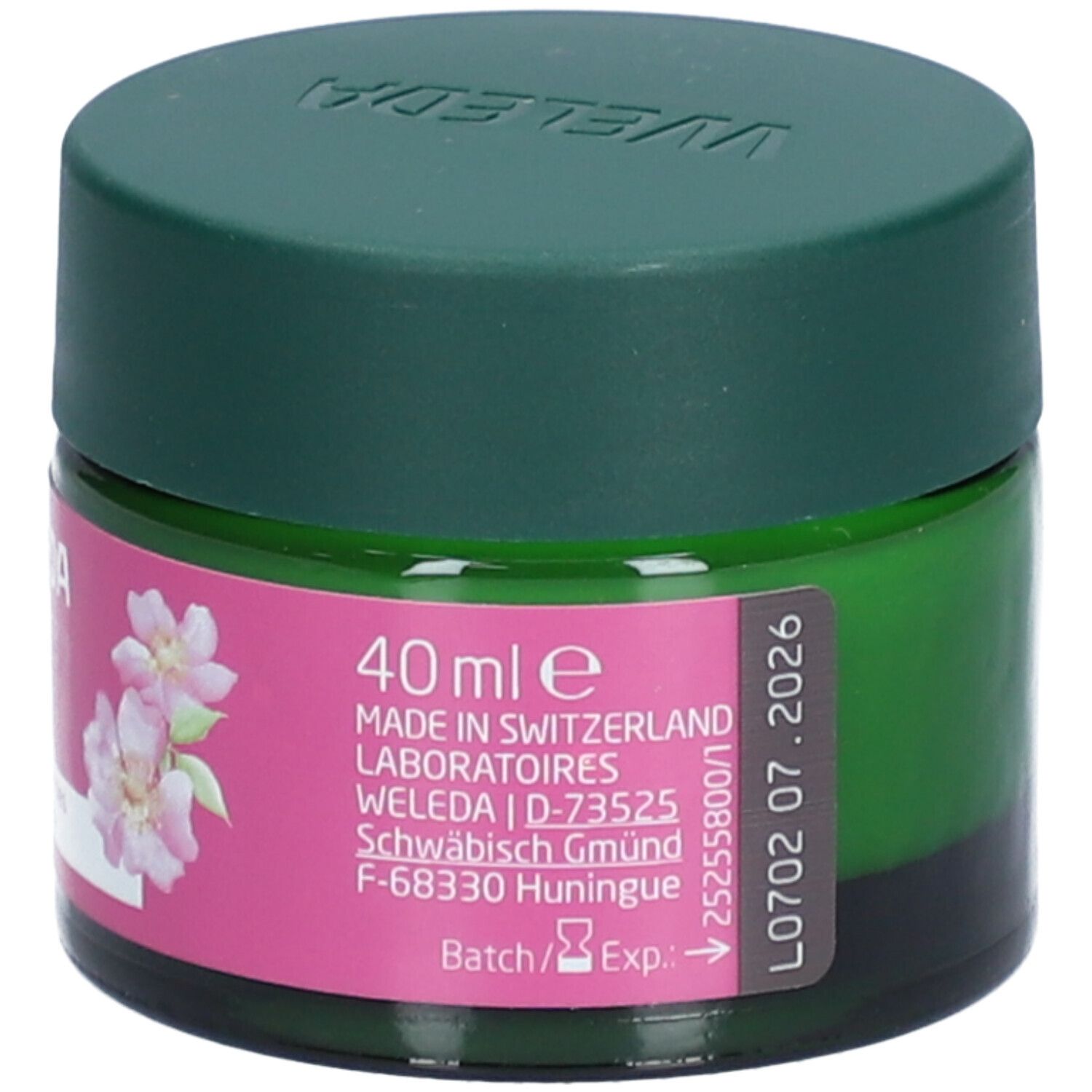 Grünes Glas mit grünem Deckel. Rosa Etikett mit Produktinformationen. Text: 40 ml e, Made in Switzerland, Weleda, Haltbarkeitsdatum.