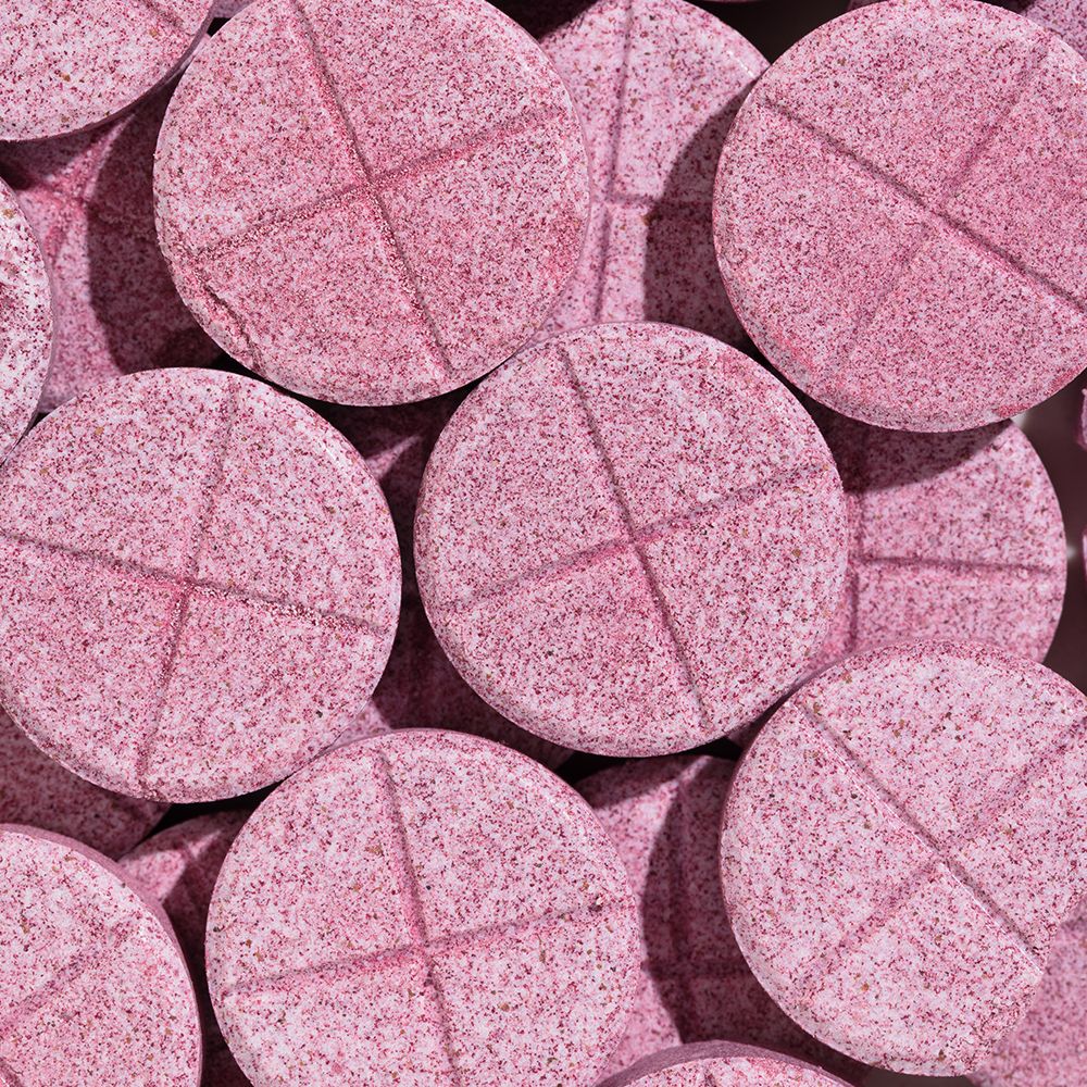 Plusieurs comprimés roses. Lignes croisées sur la surface.