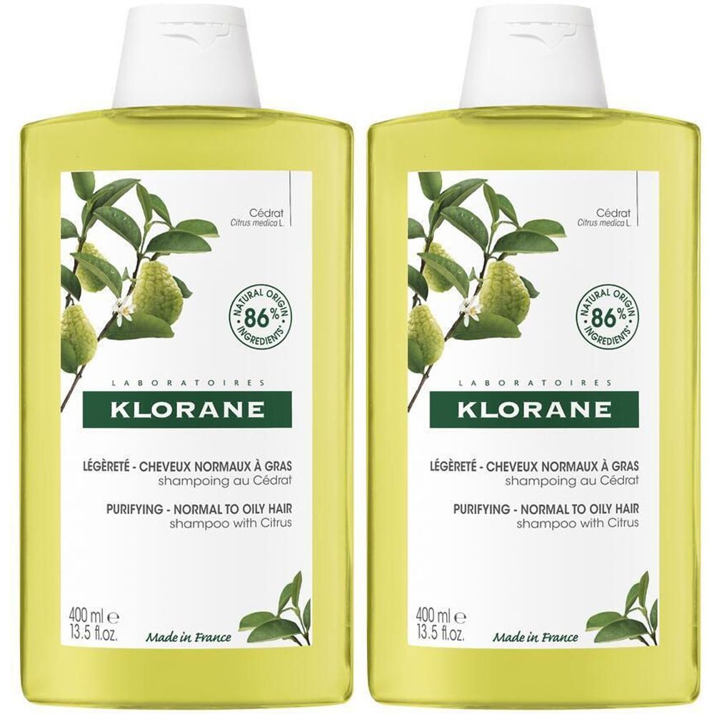 Deux flacons de shampooing KLORANE au Cédrat. Flacons jaunes avec bouchon blanc. Étiquette avec informations produit et illustration d'agrumes.