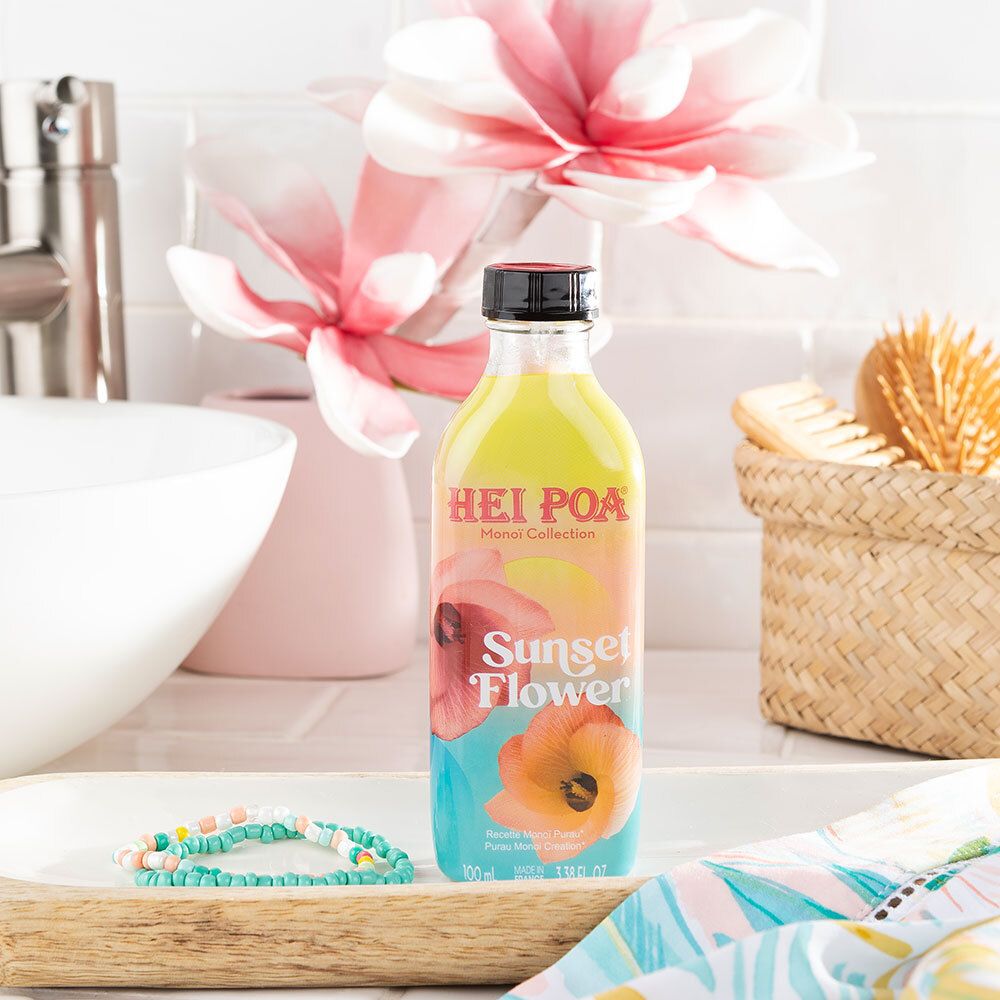 Flacon HEI POA Monoi Sunset Flower sur plateau. Scène de salle de bain avec accessoires. Bouchon noir.