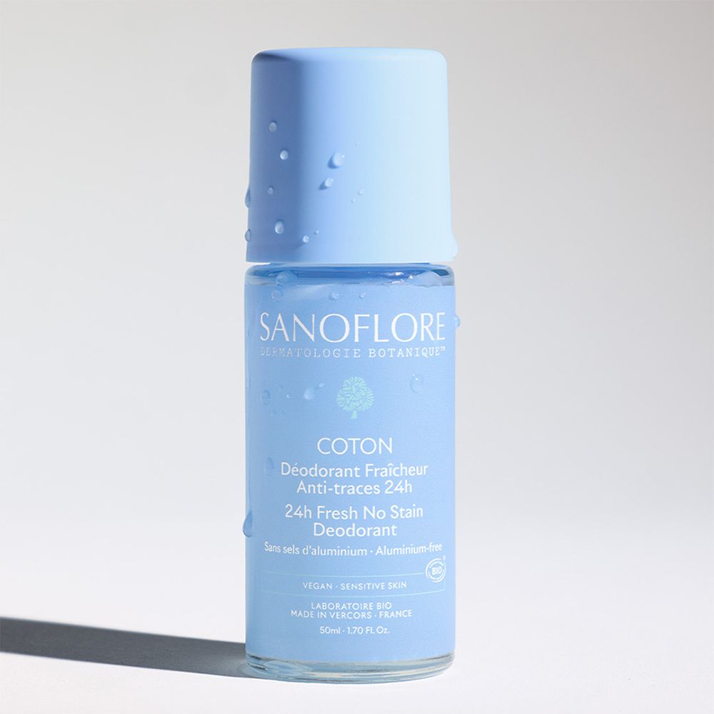 Blaues Roll-On-Deodorant. Aufschrift: Sanoflore, Coton, 24H Fresh No Stain Deodorant. Ohne Aluminiumsalze. Tropfen auf dem Deckel.