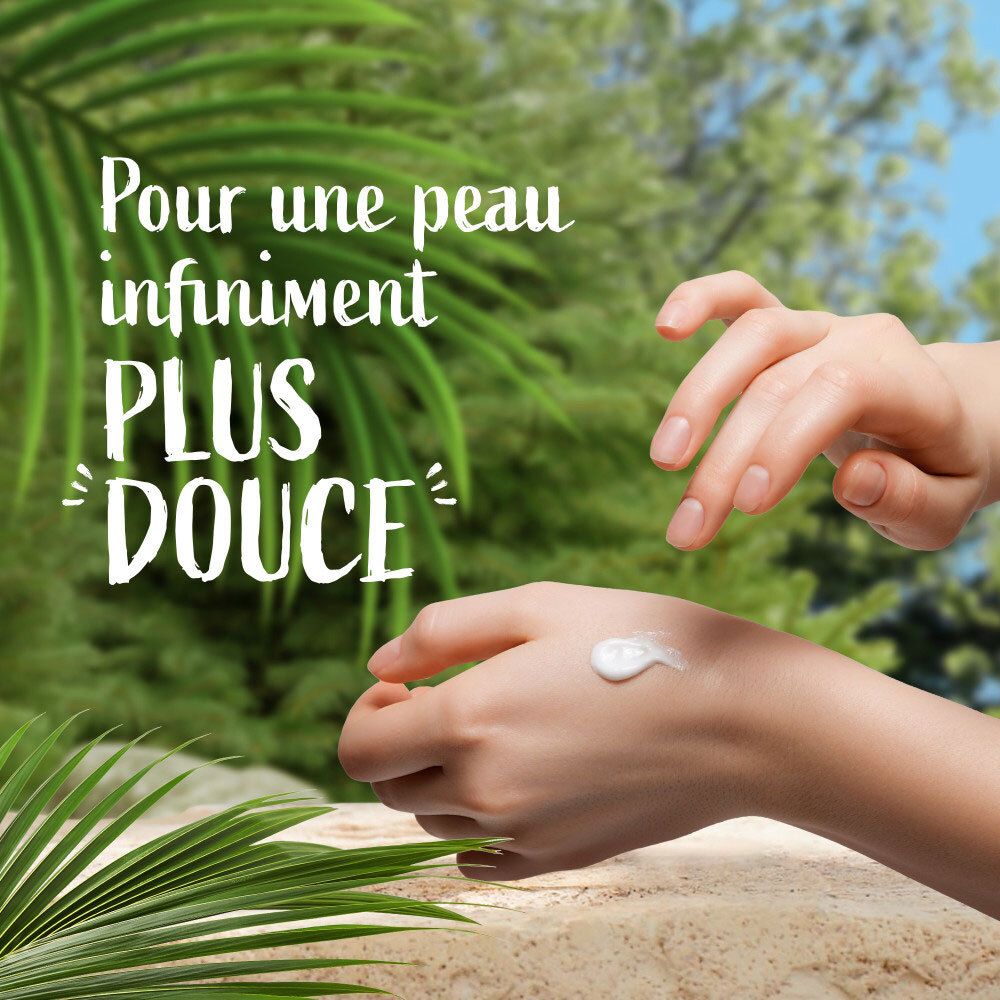 Mains avec lait de soin appliqué, texte 'Pour une peau infiniment plus douce'.